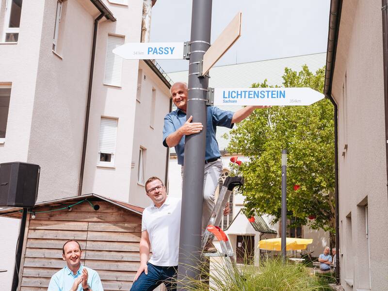 Passyjubiläum 28 - Jochen Fankhänel befreit den Wegweiser, der in seine Heimatstadt deutet. aus der Holzverkleidung