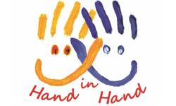 Eine mit Fingerfarben gemalte gelbe Hand und eine mit Fingerfarben gemalte blaue Hand. Darunter steht Hand in Hand.